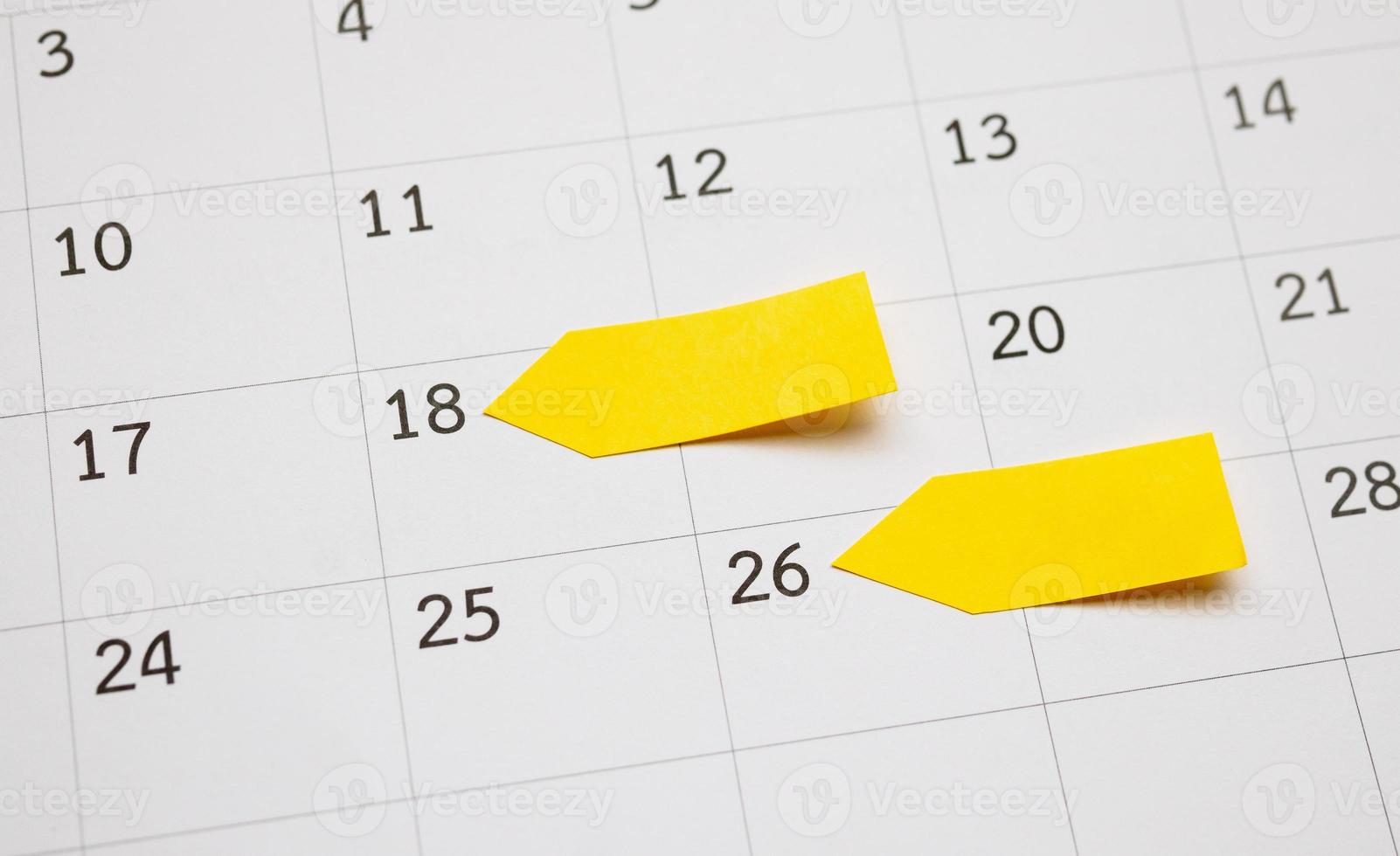 Blank yellow sticky adhesive post note paper planner with space on calendar page background for business planning appointment meeting concept photo