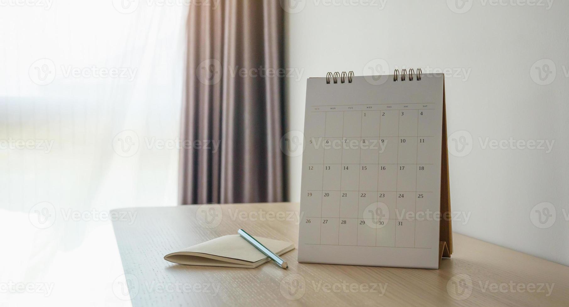 calendar page close up on wood table background with pencil and notebook business planning appointment meeting concept photo