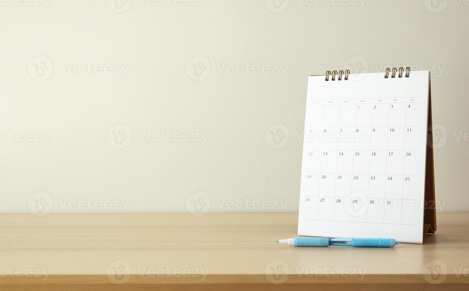 calendar page close up on wood table background with pen and notebook business planning appointment meeting concept photo