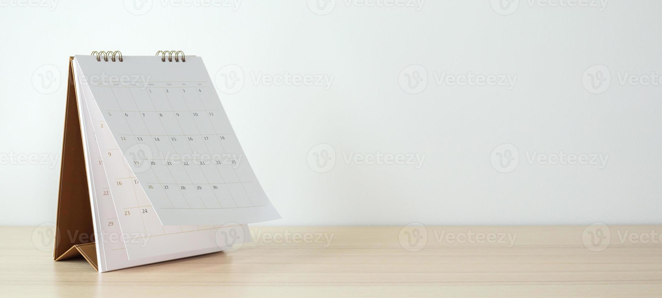 Calendar page flipping sheet on wood table background business schedule planning appointment meeting concept photo