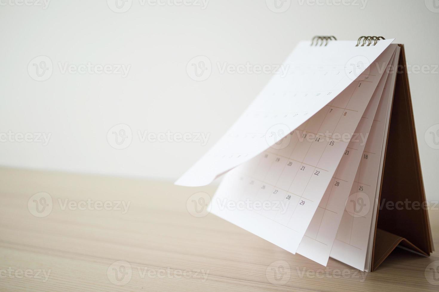 Calendar page flipping sheet on wood table background business schedule planning appointment meeting concept photo