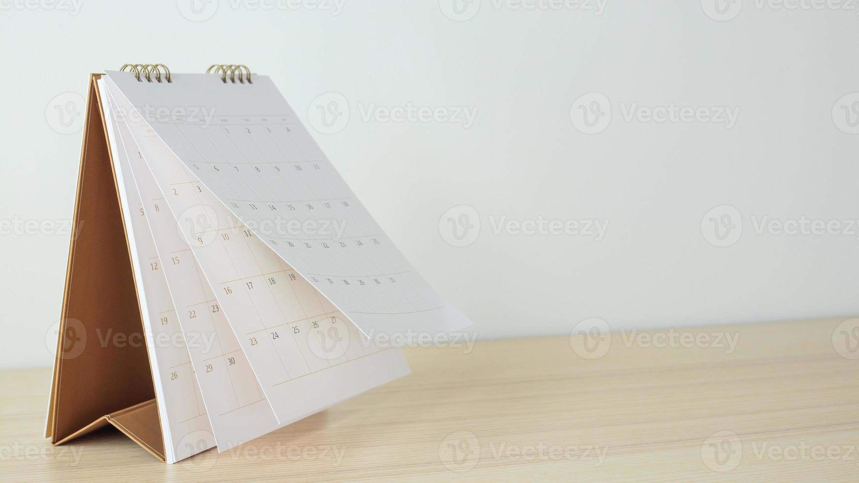 Calendar page flipping sheet on wood table background business schedule planning appointment meeting concept photo