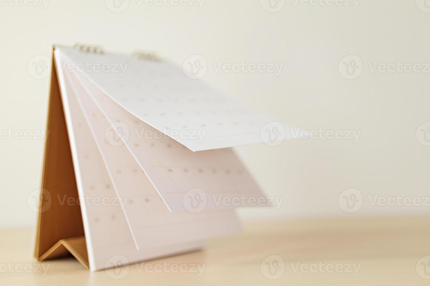 Blur Calendar page flipping sheet on wood table background business schedule planning appointment meeting concept photo
