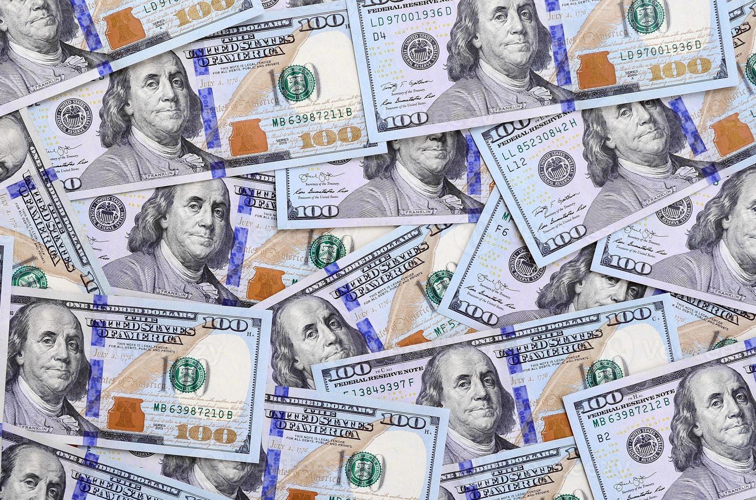 A large number of US dollar bills of a new design with a blue stripe in the middle. Top view photo