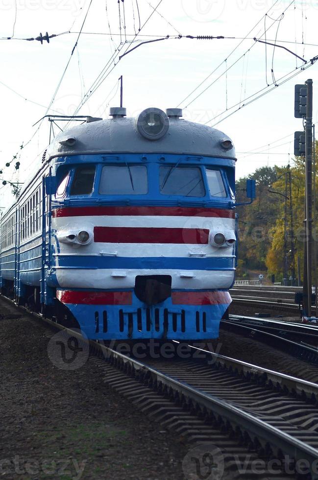 Old soviet electric train with outdated design moving by rail photo