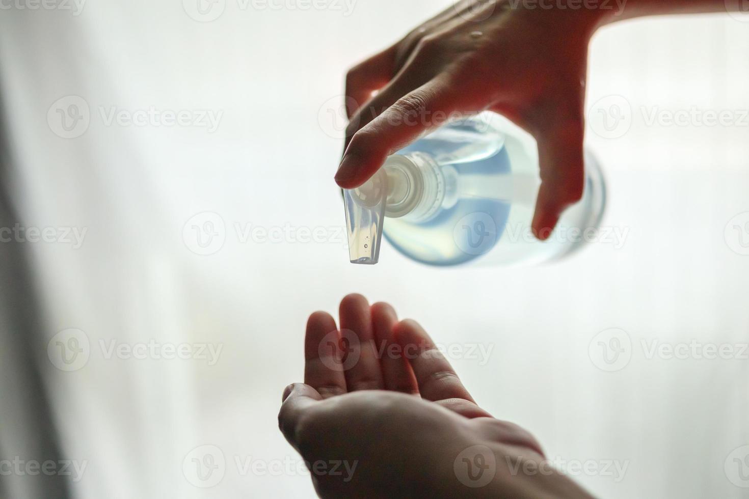 mujer que usa gel desinfectante con alcohol para limpiar la mano concepto de prevención del virus corona covid-19 foto