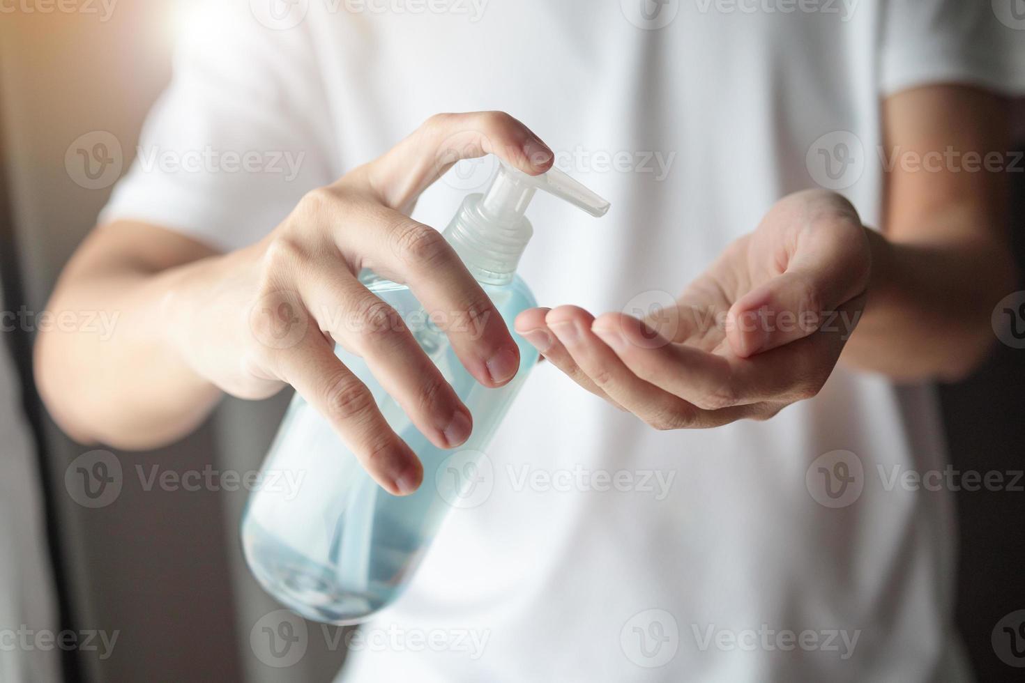 hombre que usa gel desinfectante con alcohol para limpiar la mano concepto de prevención del virus corona covid-19 foto