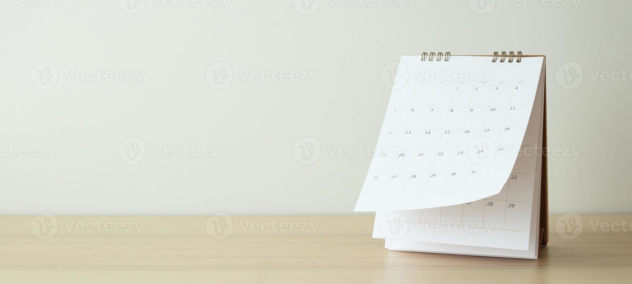 Calendar page flipping sheet on wood table background business schedule planning appointment meeting concept photo