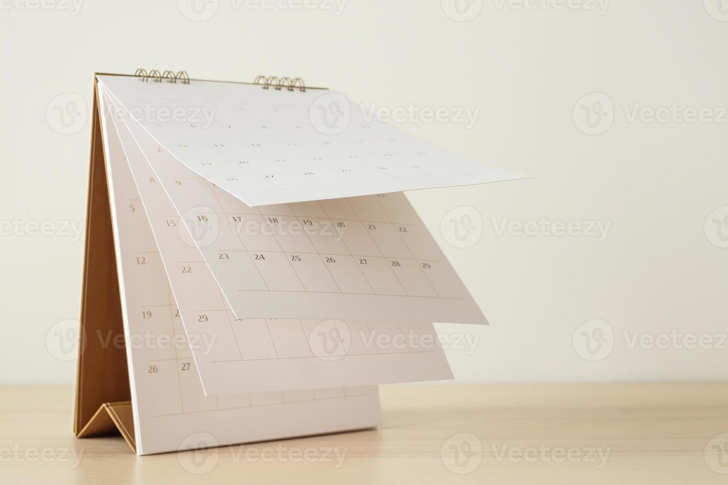 Calendar page flipping sheet on wood table background business schedule planning appointment meeting concept photo