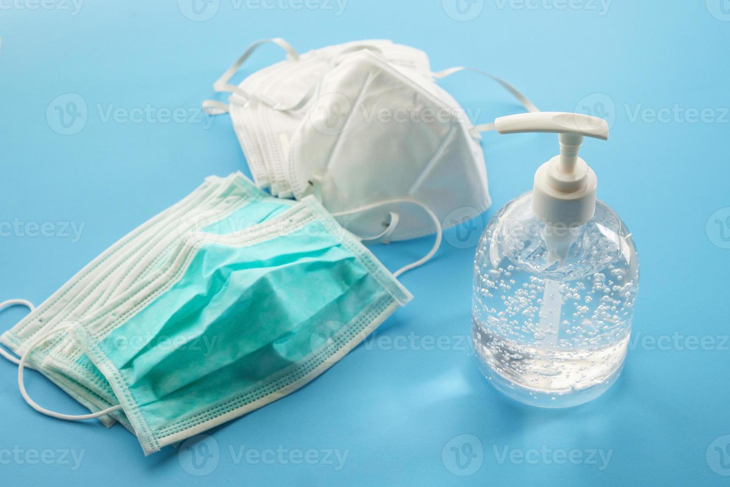 Alcohol sanitizer gel hand wash bottle with N95 Medical face mask on blue background covid-19 Coronavirus prevention concept photo