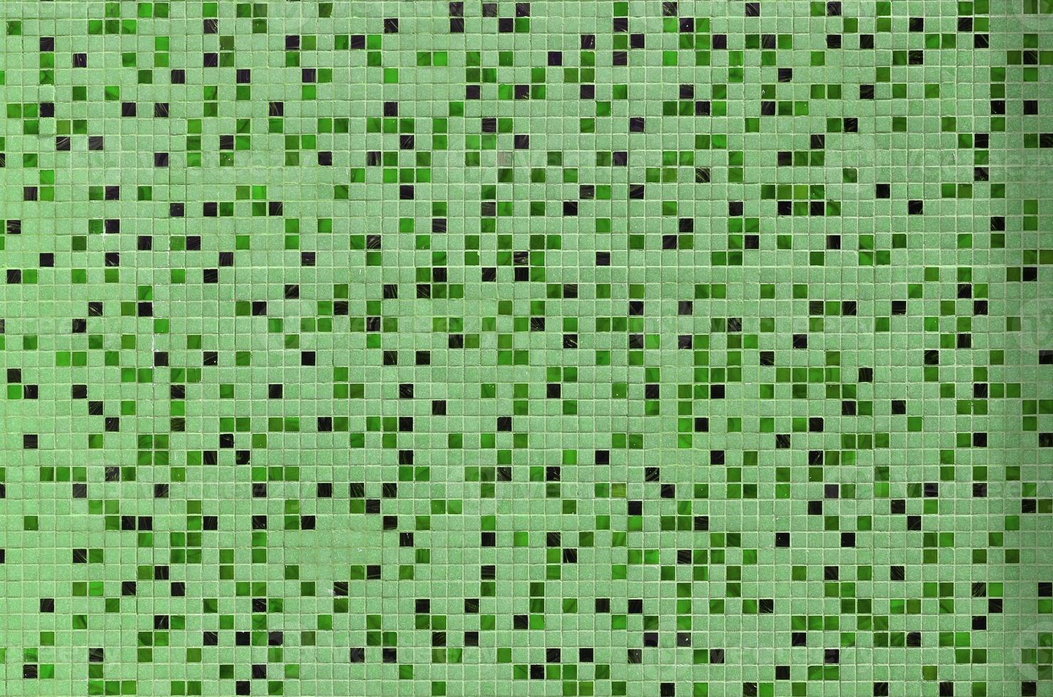 The texture of the wall, decorated with a mosaic of various small square tiles. Abstract pattern of ceramic tiles on the wall photo