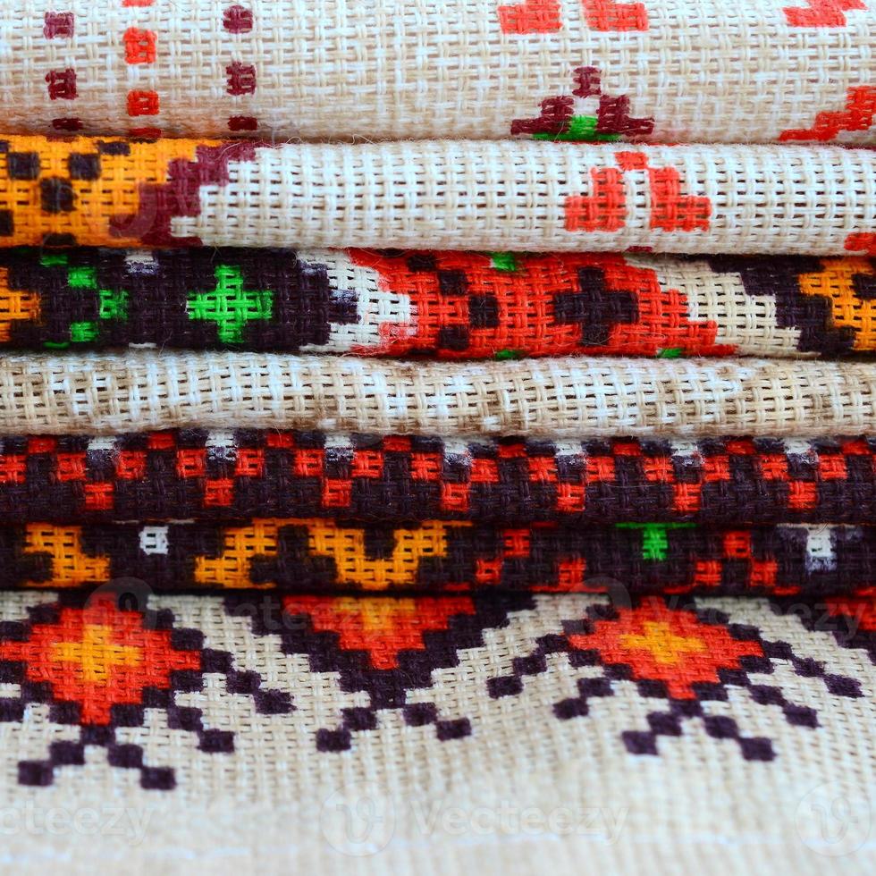 Stack of traditional Ukrainian folk art knitted embroidery patterns on textile fabric photo