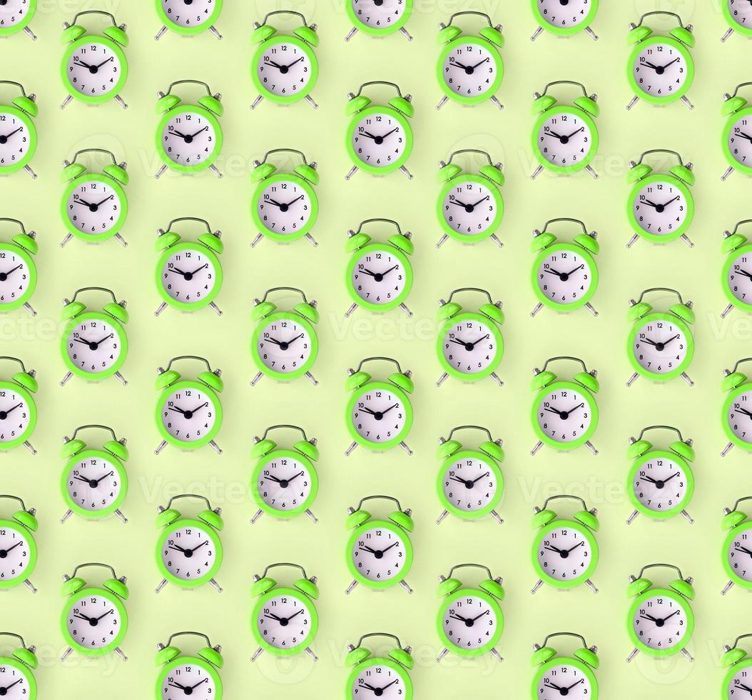 Wasting time concept. Many green alarm clock photo