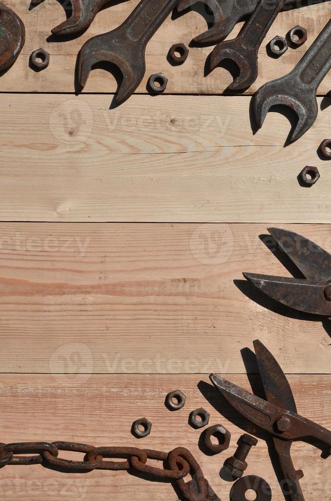 un conjunto de herramientas viejas y oxidadas se encuentra sobre una mesa de madera en el taller foto