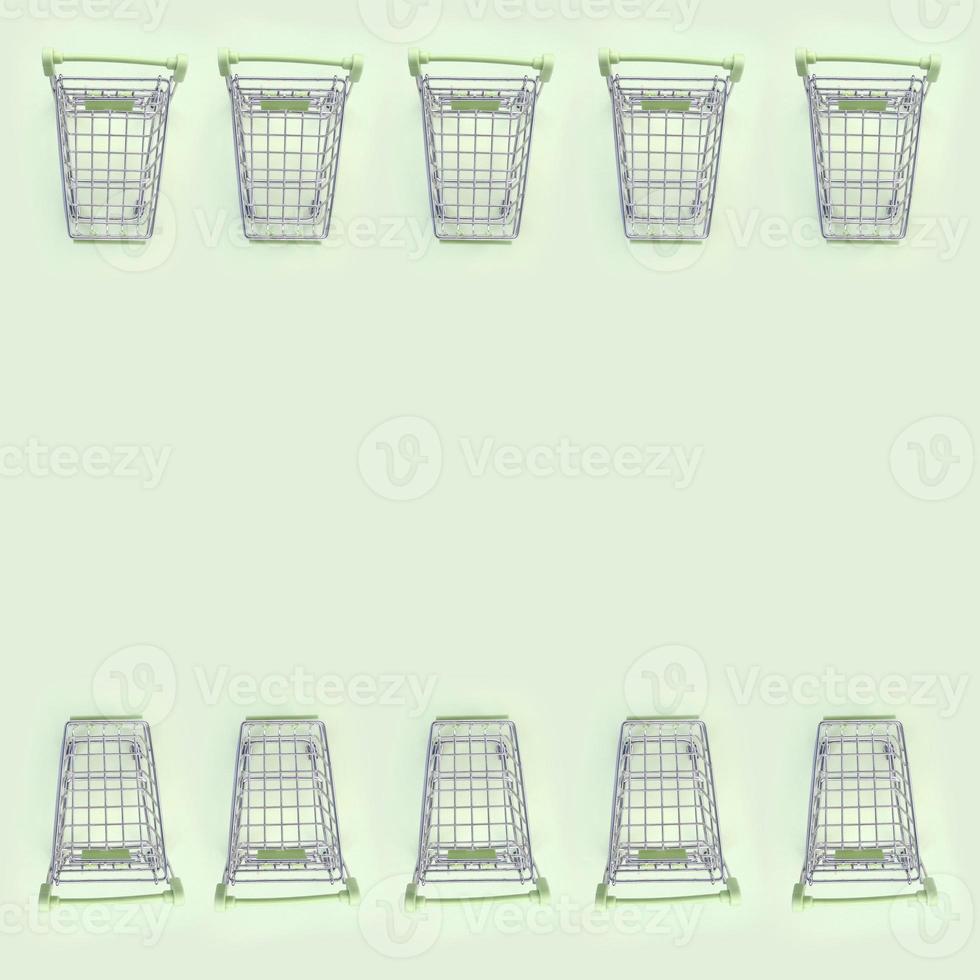 Pattern of many small shopping carts on a lime background photo