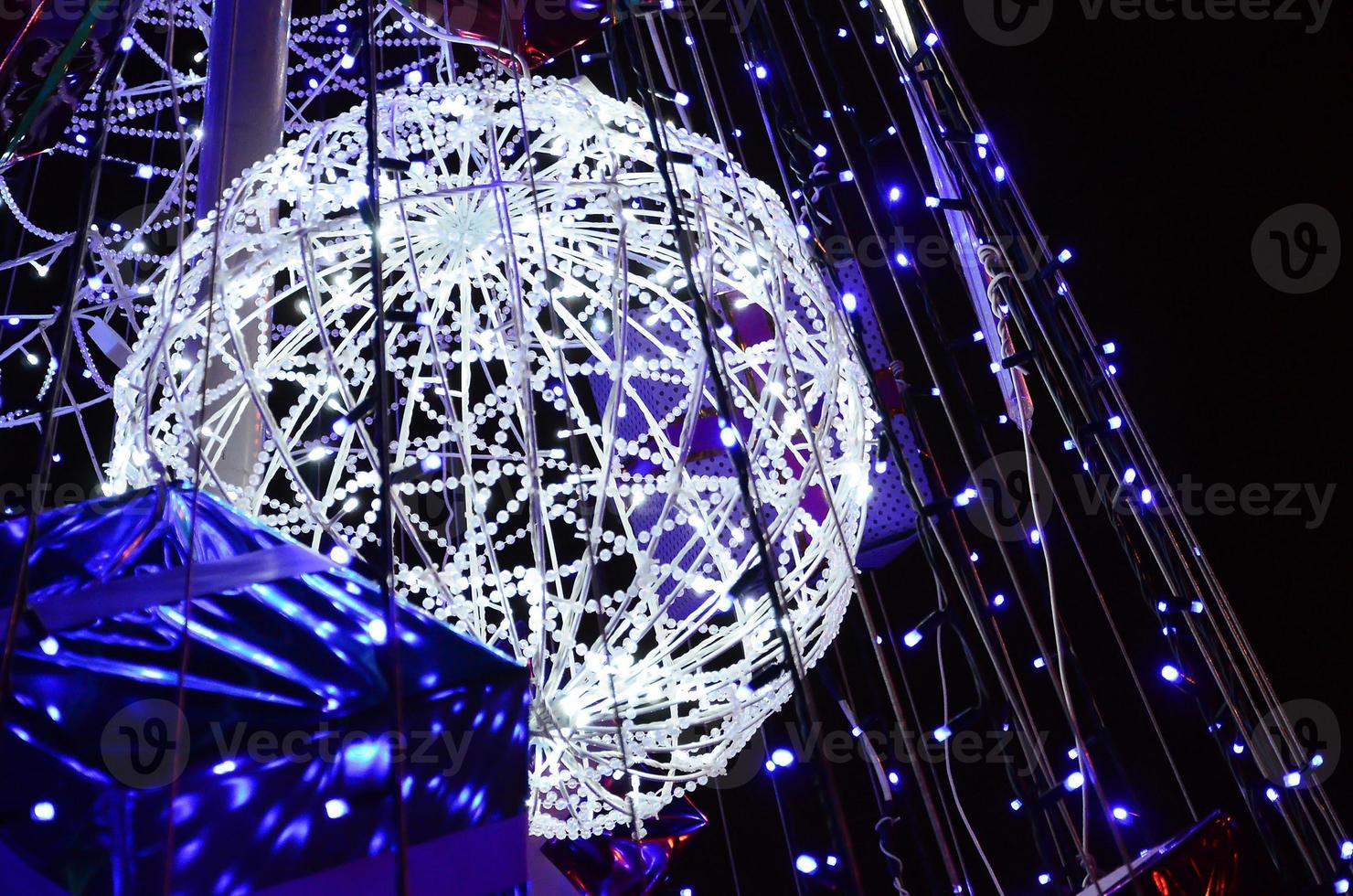 Fragment of the New Year tree. A lot of round lights of blue color are located on a conical frame photo