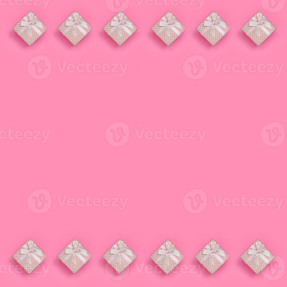 A lot of pink gift boxes lies on texture background of fashion pastel pink color paper in minimal concept. Abstract trendy pattern photo