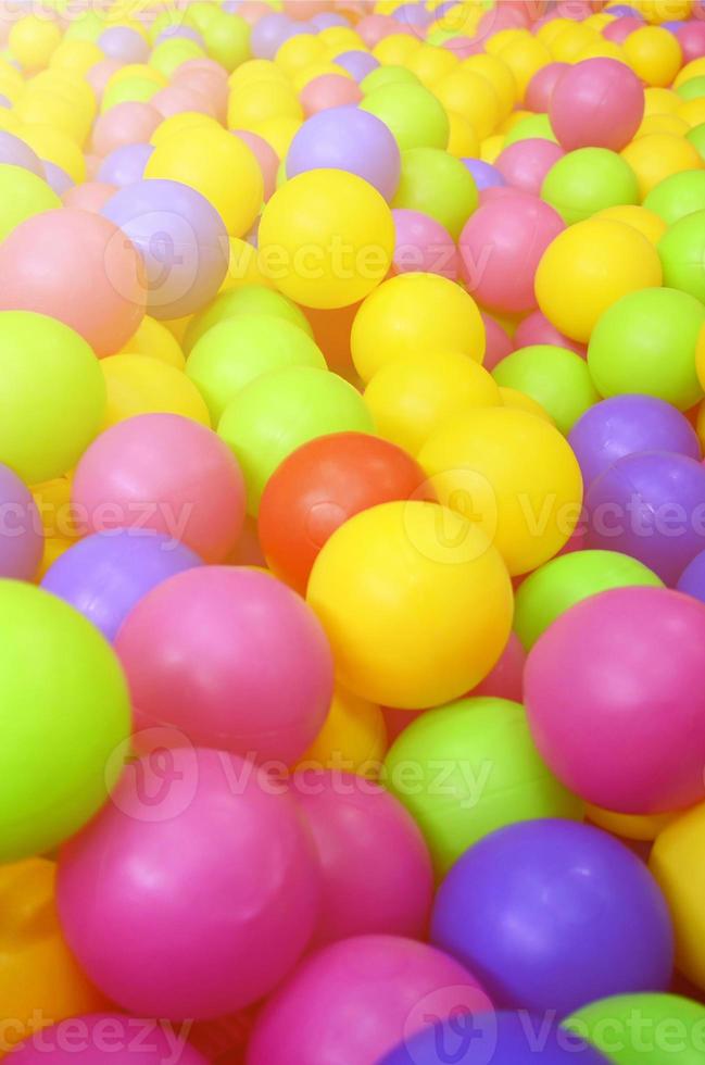 Many colorful plastic balls in a kids' ballpit at a playground. Close up pattern photo