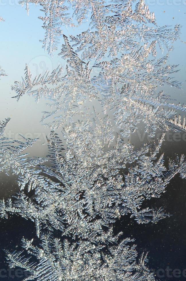 Snowflakes frost rime macro on window glass pane photo