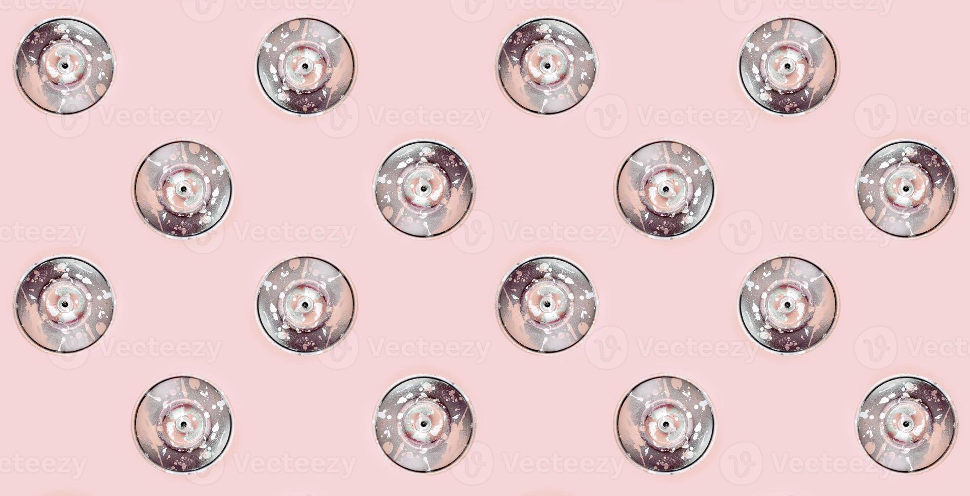 Many used spray cans for graffiti drawing lies on a pastel colored backgroung. Street art painting concept. Minimal flat lay pattern. Top view photo