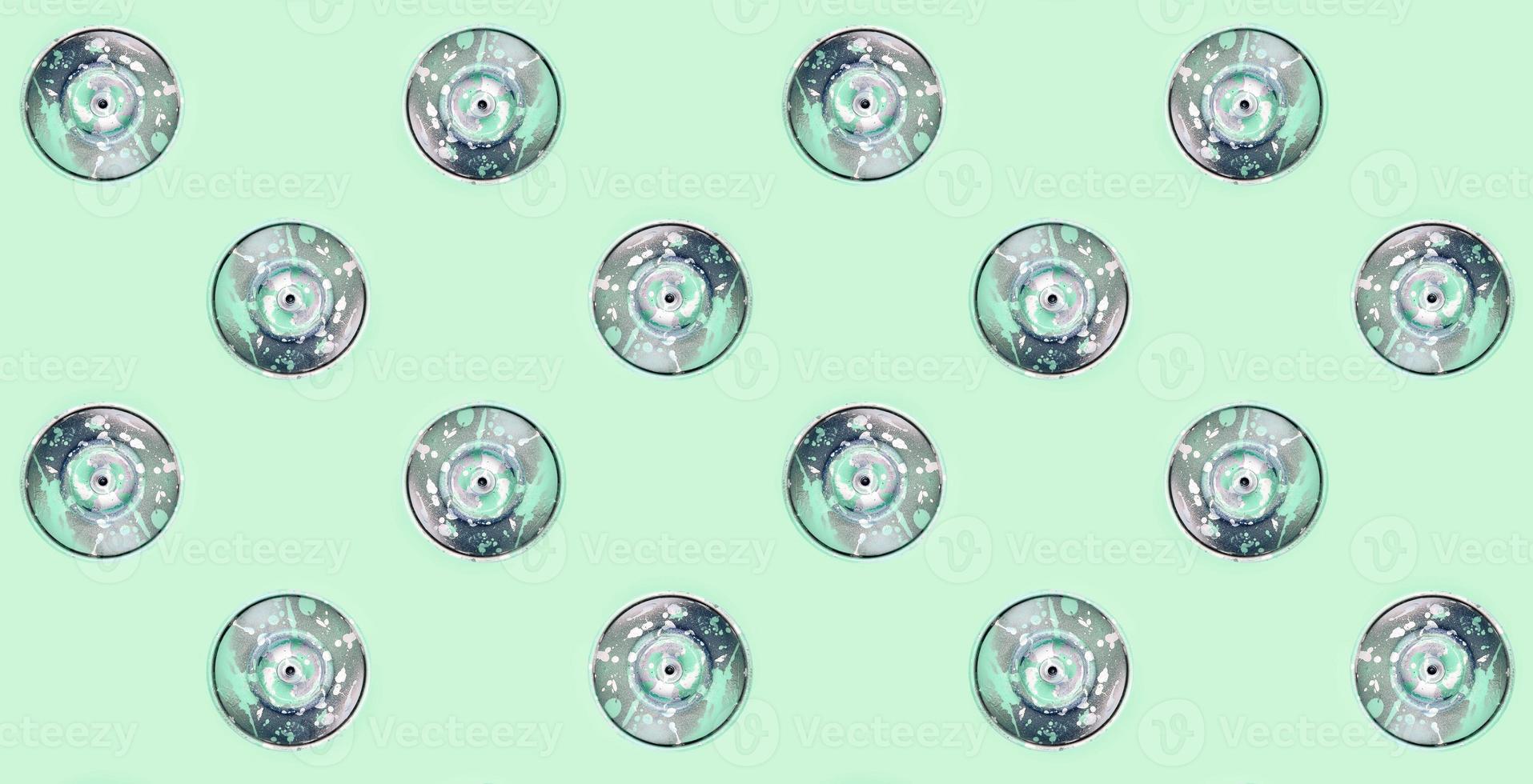 Many used spray cans for graffiti drawing lies on a pastel colored backgroung. Street art painting concept. Minimal flat lay pattern. Top view photo