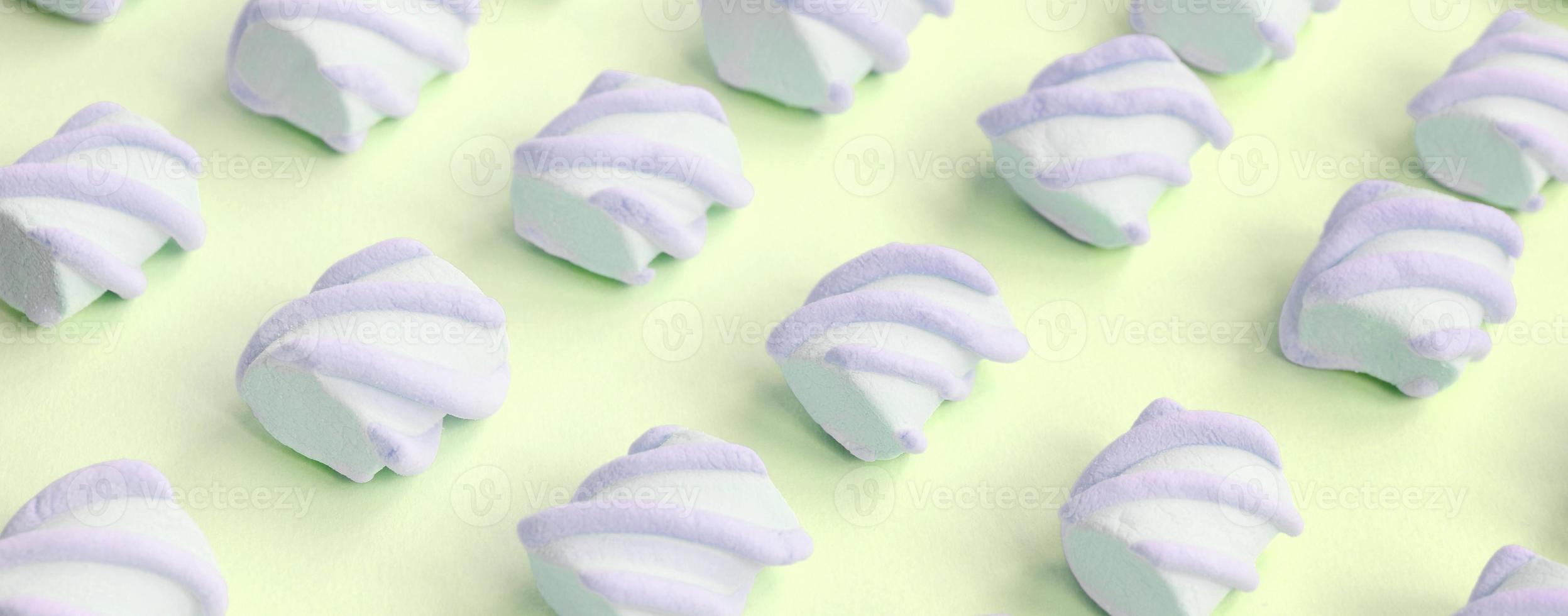Colorful marshmallow laid out on lime paper background. pastel creative textured pattern photo