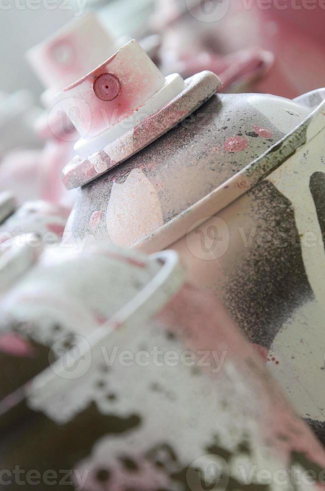 muchas latas de aerosol sucias y usadas de pintura rosa brillante. fotografía macro con poca profundidad de campo. enfoque selectivo en la boquilla de pulverización foto