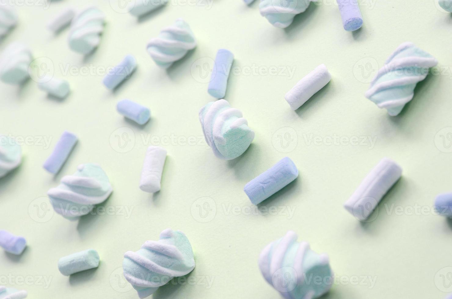 Colorful marshmallow laid out on lime paper background. pastel creative textured pattern photo