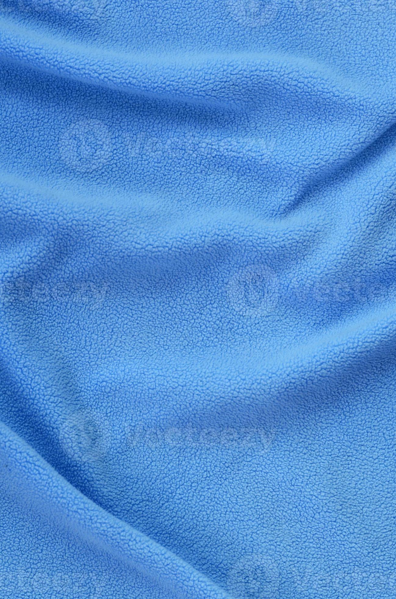The blanket of furry blue fleece fabric. A background of light blue