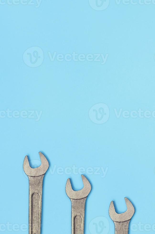 tres llaves metálicas yacen sobre la textura del fondo del papel de color azul pastel de moda foto