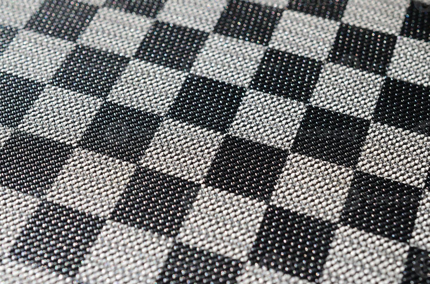 Plastic texture in the form of a very small cloth binding, painted in black and gray in the style of a chessboard. Macro shot photo