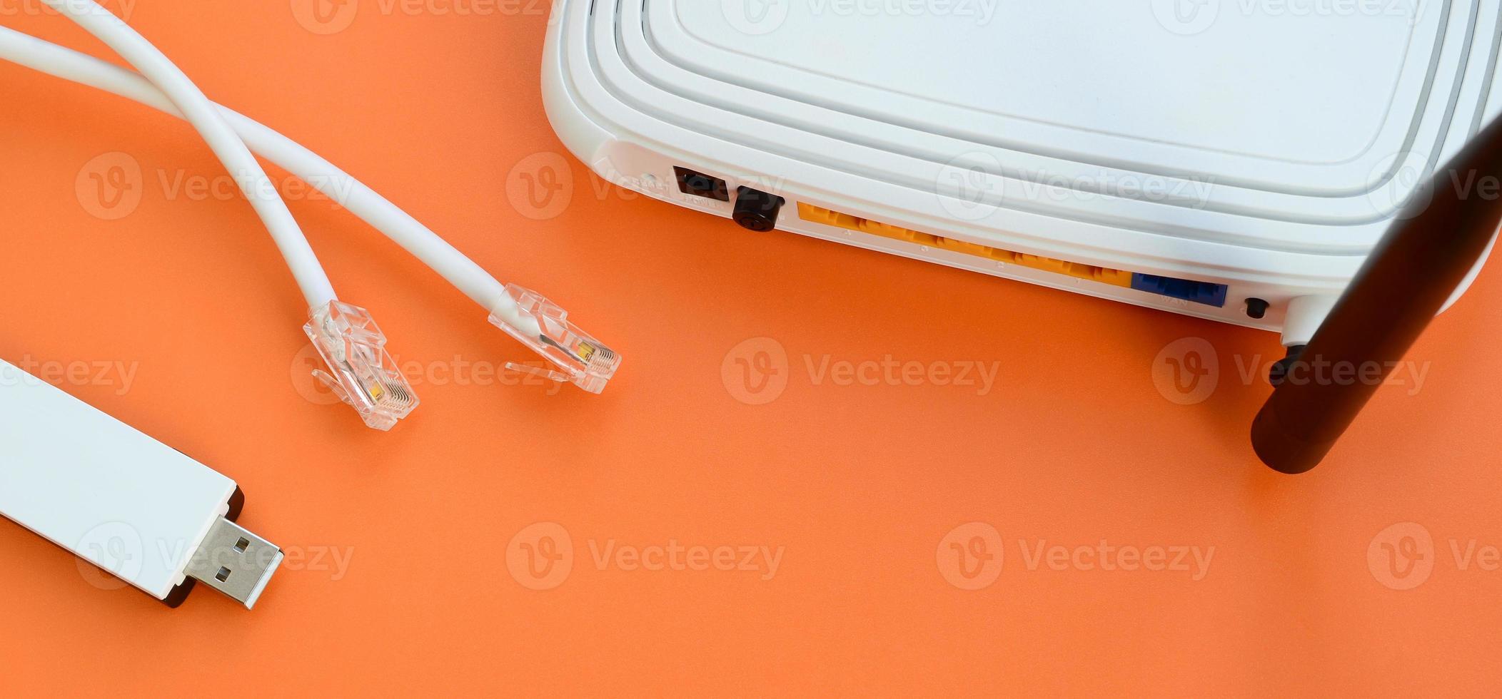 Internet router, portable USB wi-fi adapter and internet cable plugs lie on a bright orange background. Items required for internet connection photo