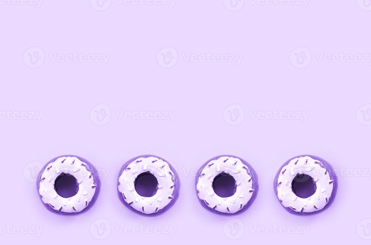 Many small plastic donuts lies on a pastel colorful background. Flat lay minimal pattern. Top view photo