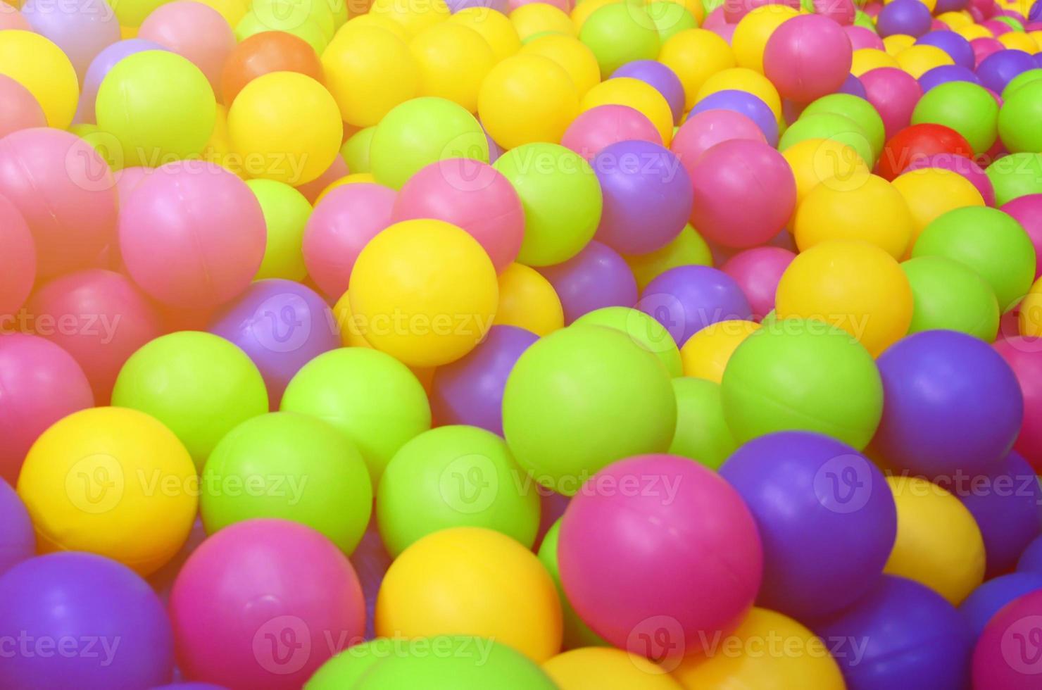 Many colorful plastic balls in a kids' ballpit at a playground. Close up pattern photo