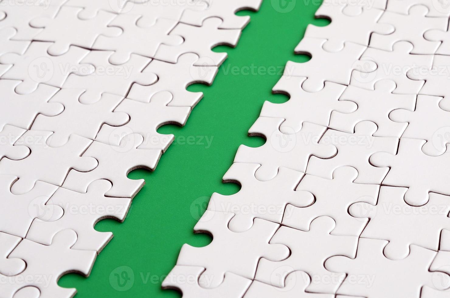 The green path is laid on the platform of a white folded jigsaw puzzle. Texture image with copy space for text photo