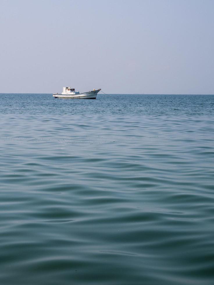 vista frontal que miraba botes de pesca pequeños y medianos, estaba estacionado en medio del mar después de pescar en el mar azul y cielo despejado viento tranquilo agua de mar playa bangsaen este de tailandia chonburi foto