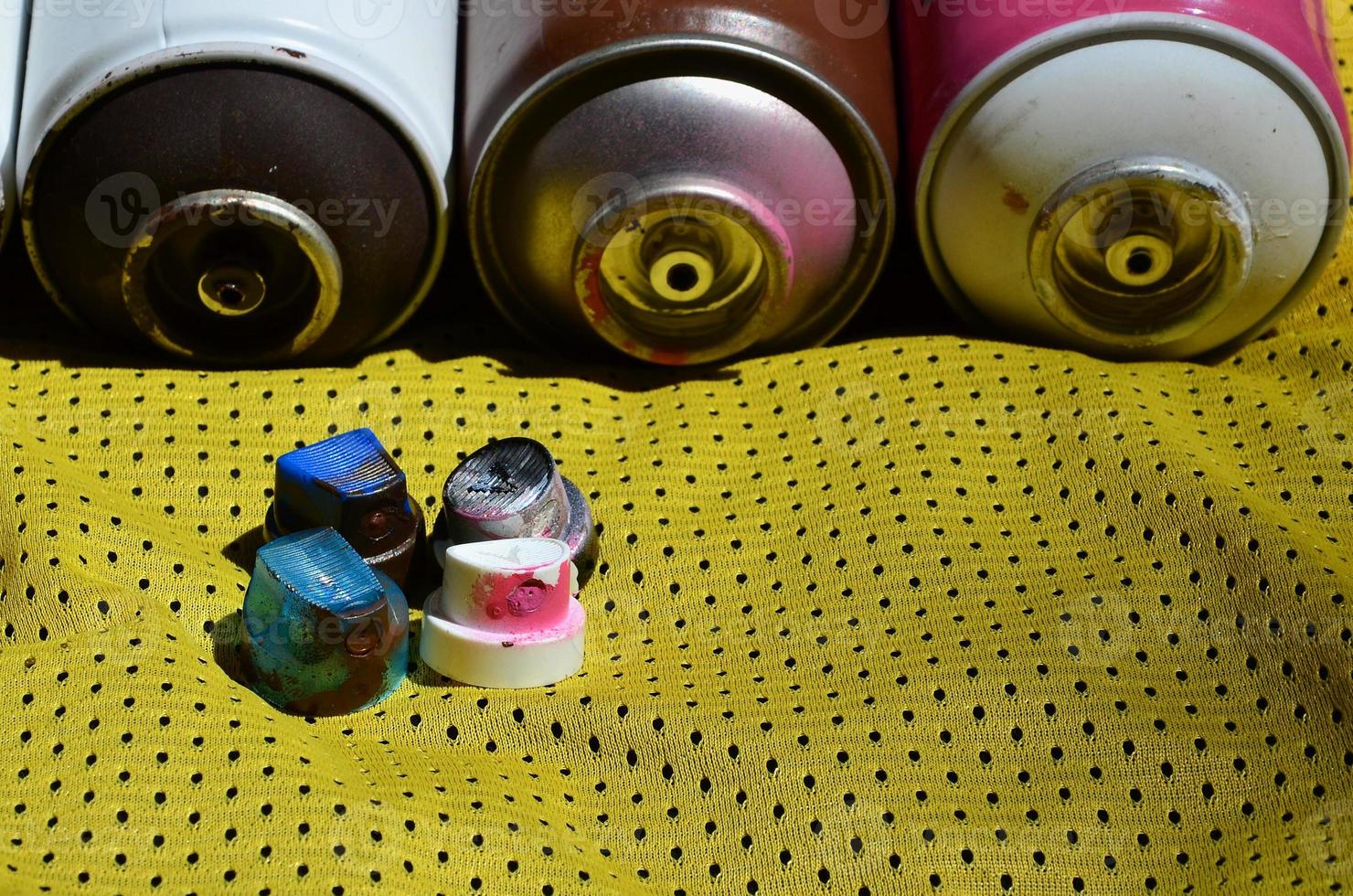 Several caps for used aerosol paint sprayers lie on the sports shirt of a basketball player made of polyester fabric. The concept of youth street art, active sports and eventful lifestyle photo