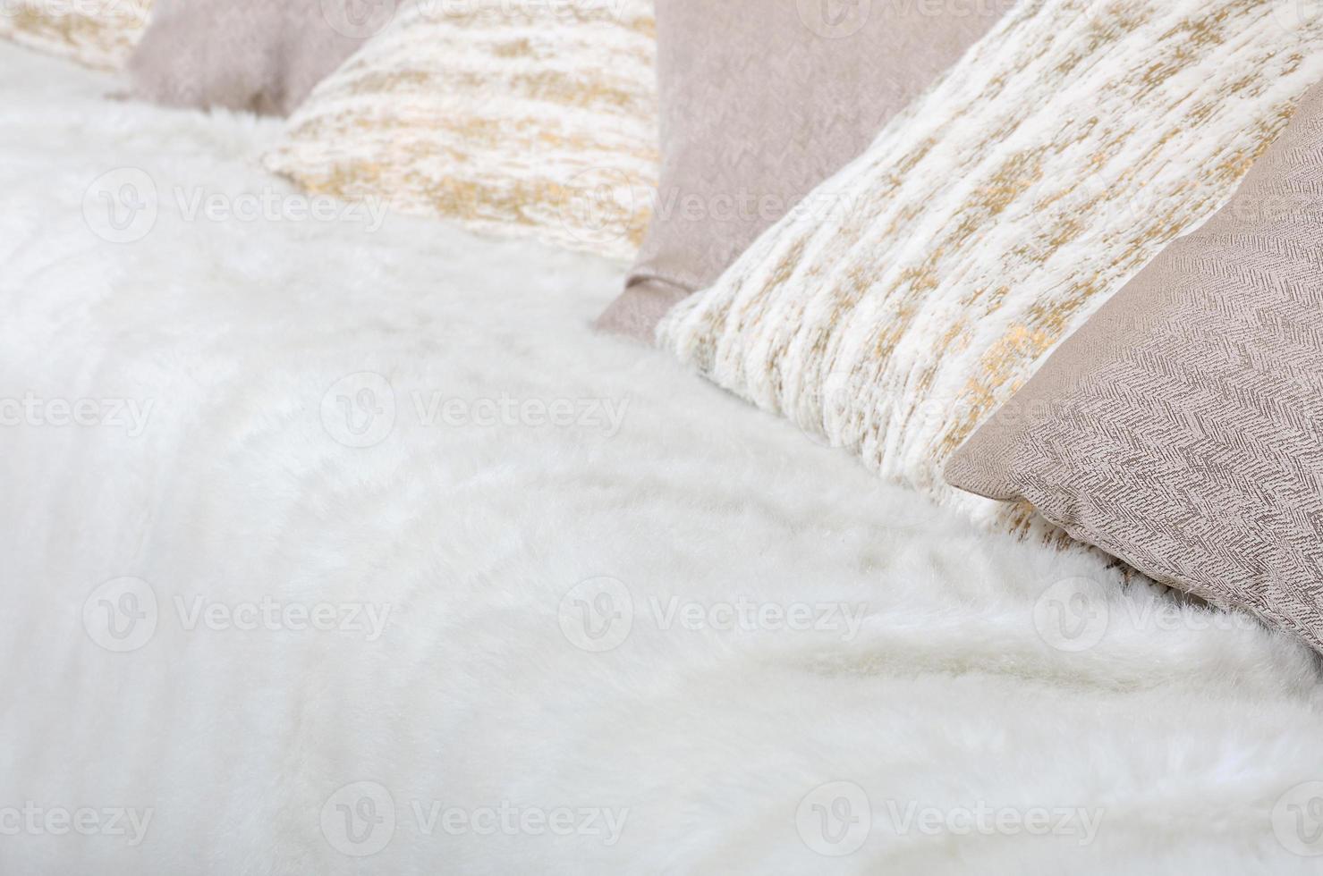 Many pillows lie on the couch, which is covered with a large plush veil
