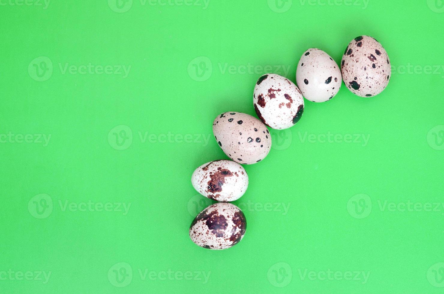 Quail eggs on a light green surface, top view, empty place for t photo