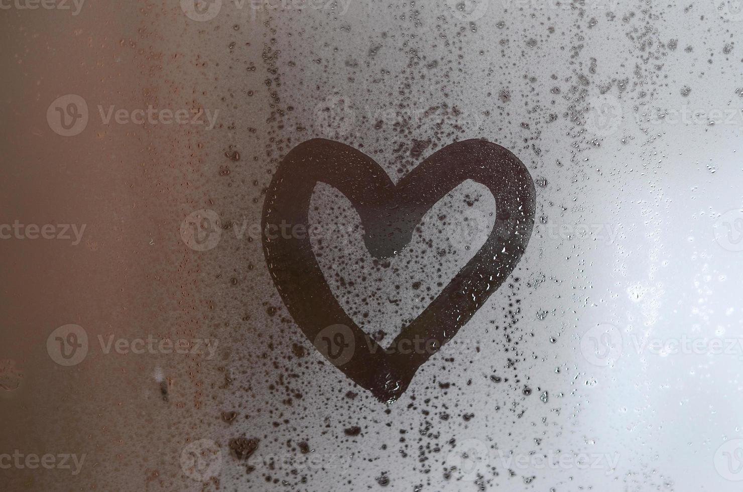 The heart is painted on the misted glass in the winter photo