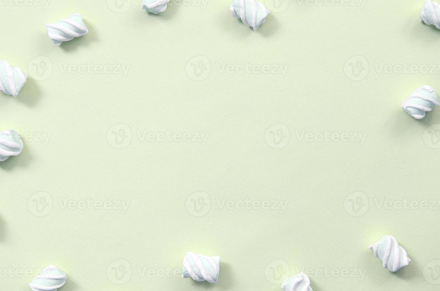 Colorful marshmallow laid out on lime paper background. pastel creative textured framework photo