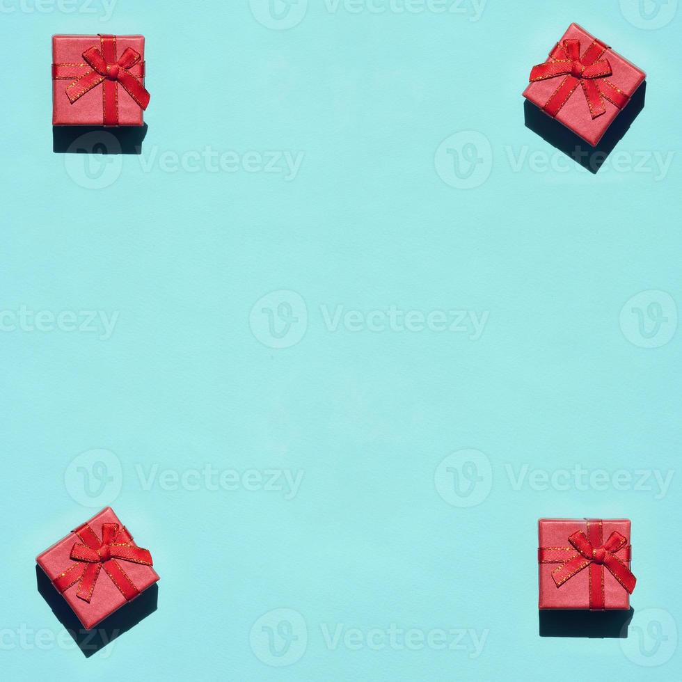 Many small red pink gift boxes on texture background of fashion trendy pastel blue color paper in minimal concept. Abstract pattern photo