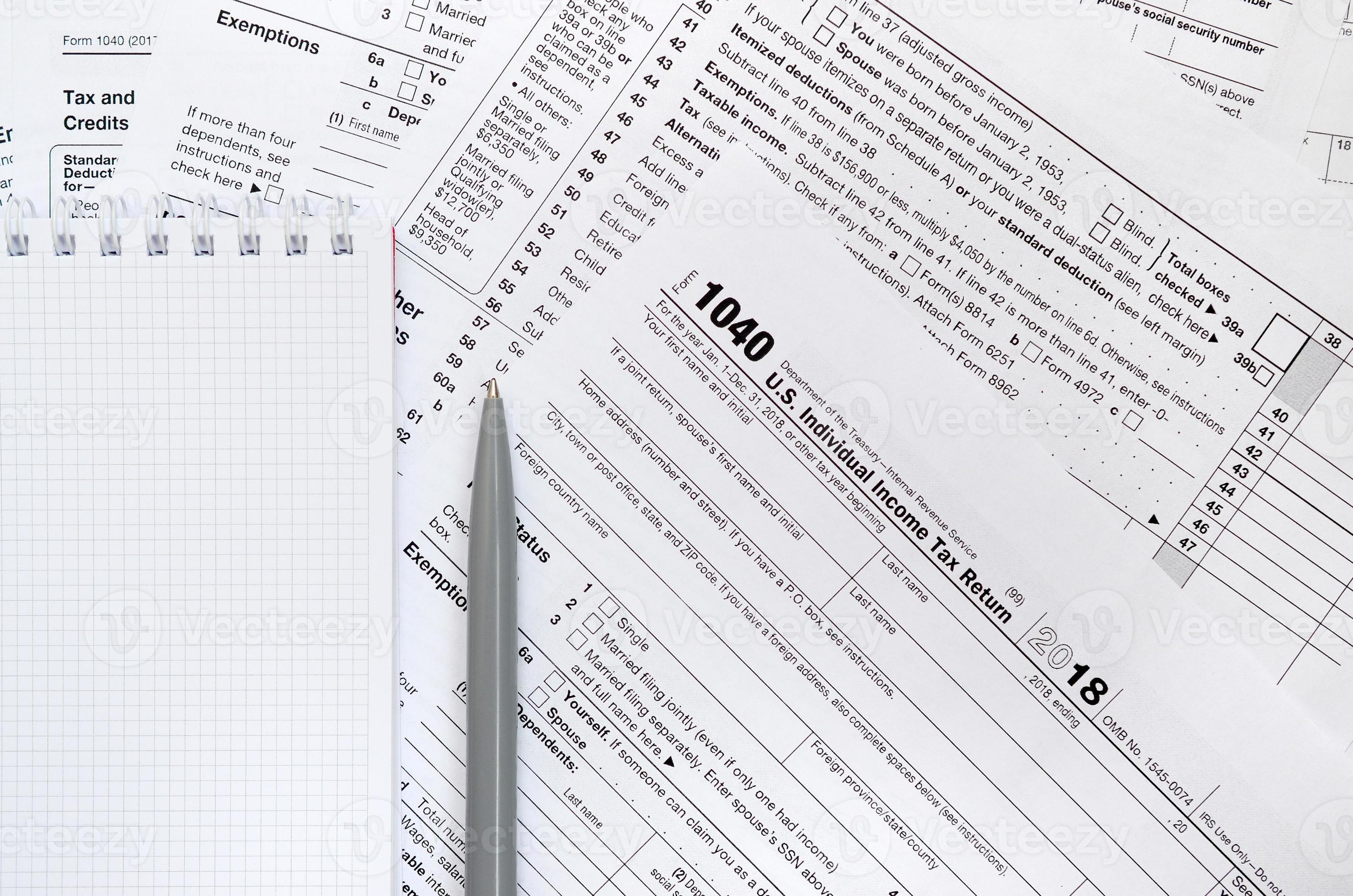 The pen and notebook is lies on the tax form 1040 U.S. Individual