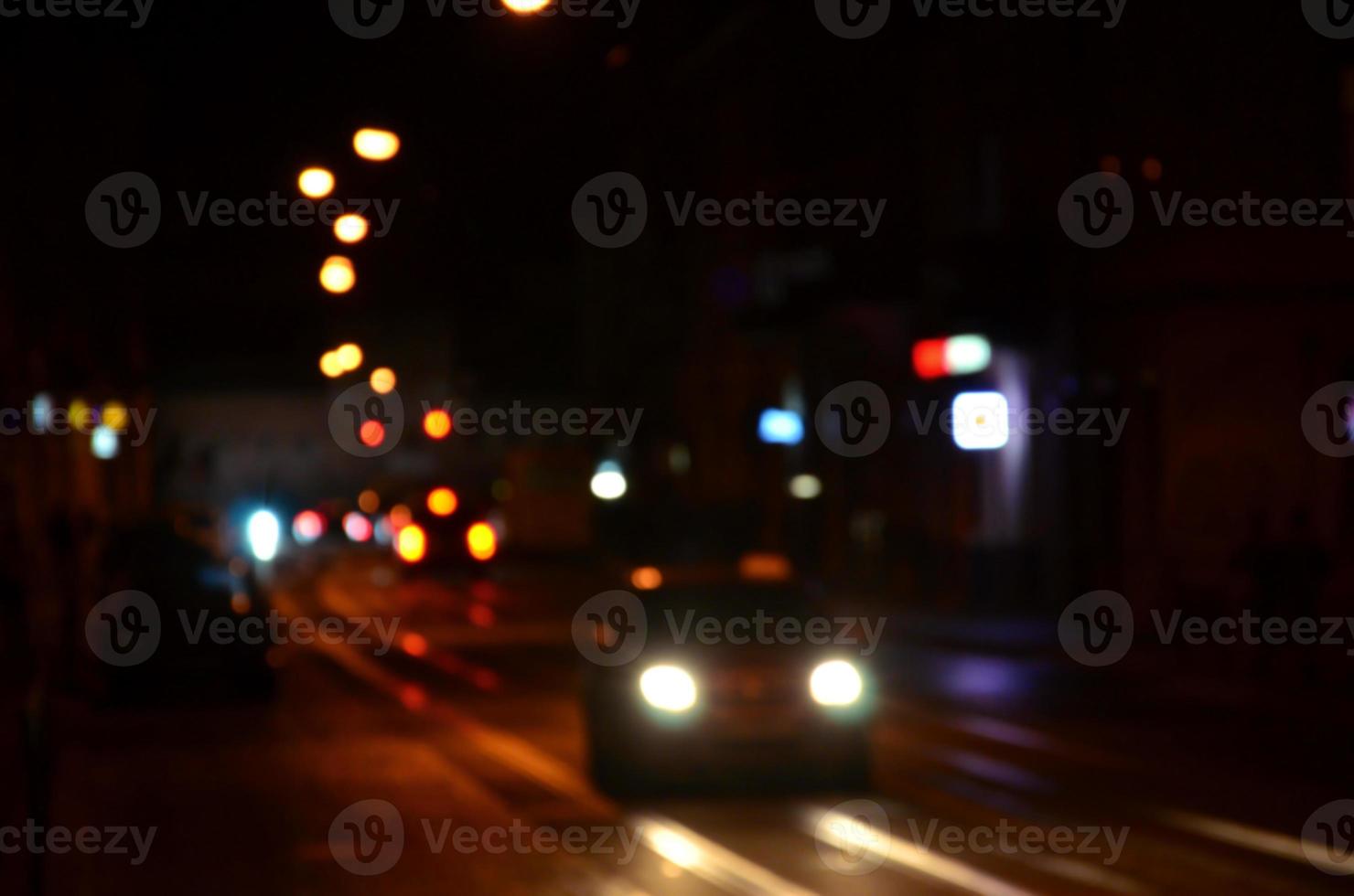 Blurred night scene of traffic on the roadway. Defocused image of cars traveling with luminous headlights. Bokeh Art photo