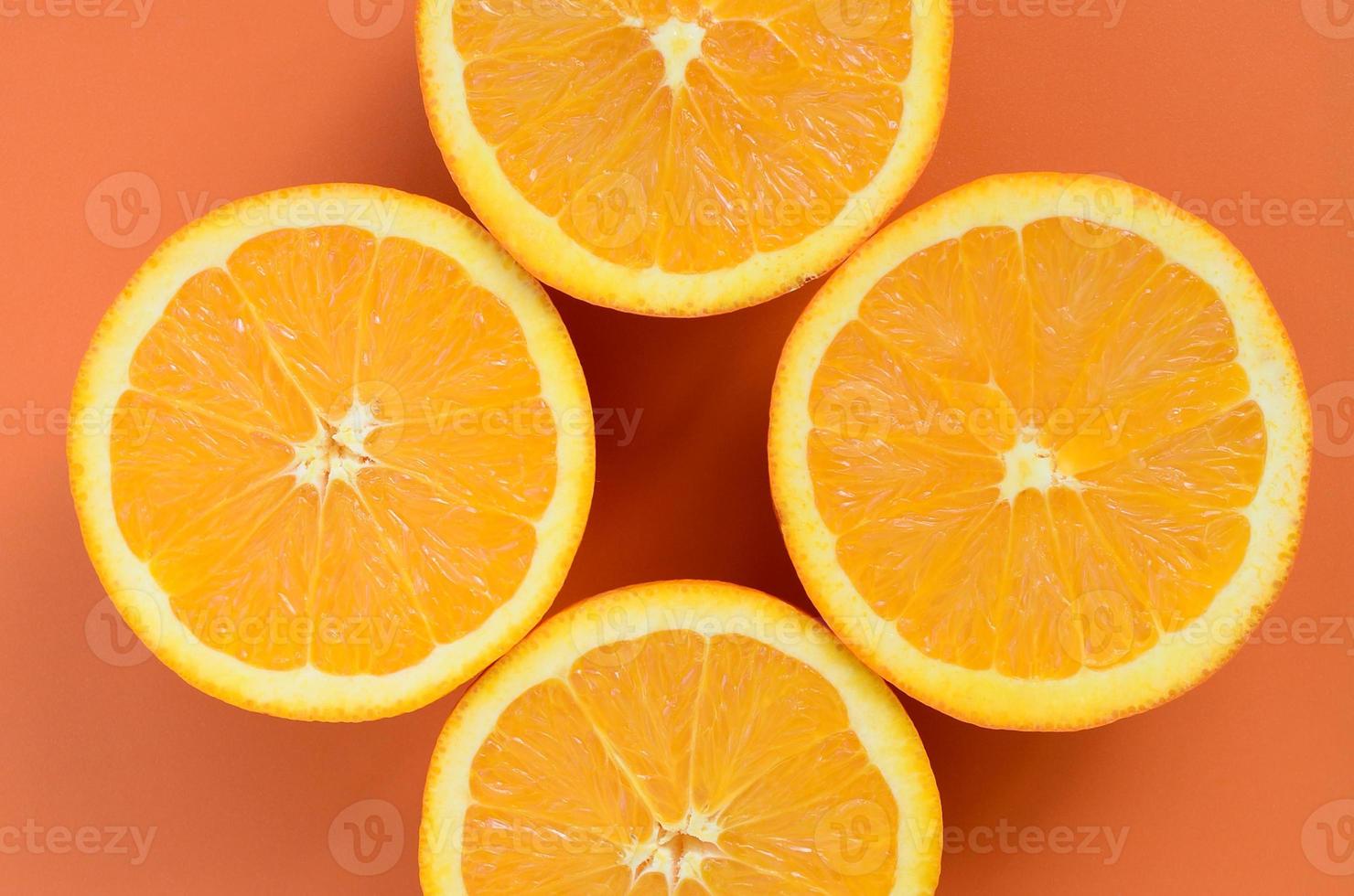Top view of a several orange fruit slices on bright background in orange color. A saturated citrus texture image photo