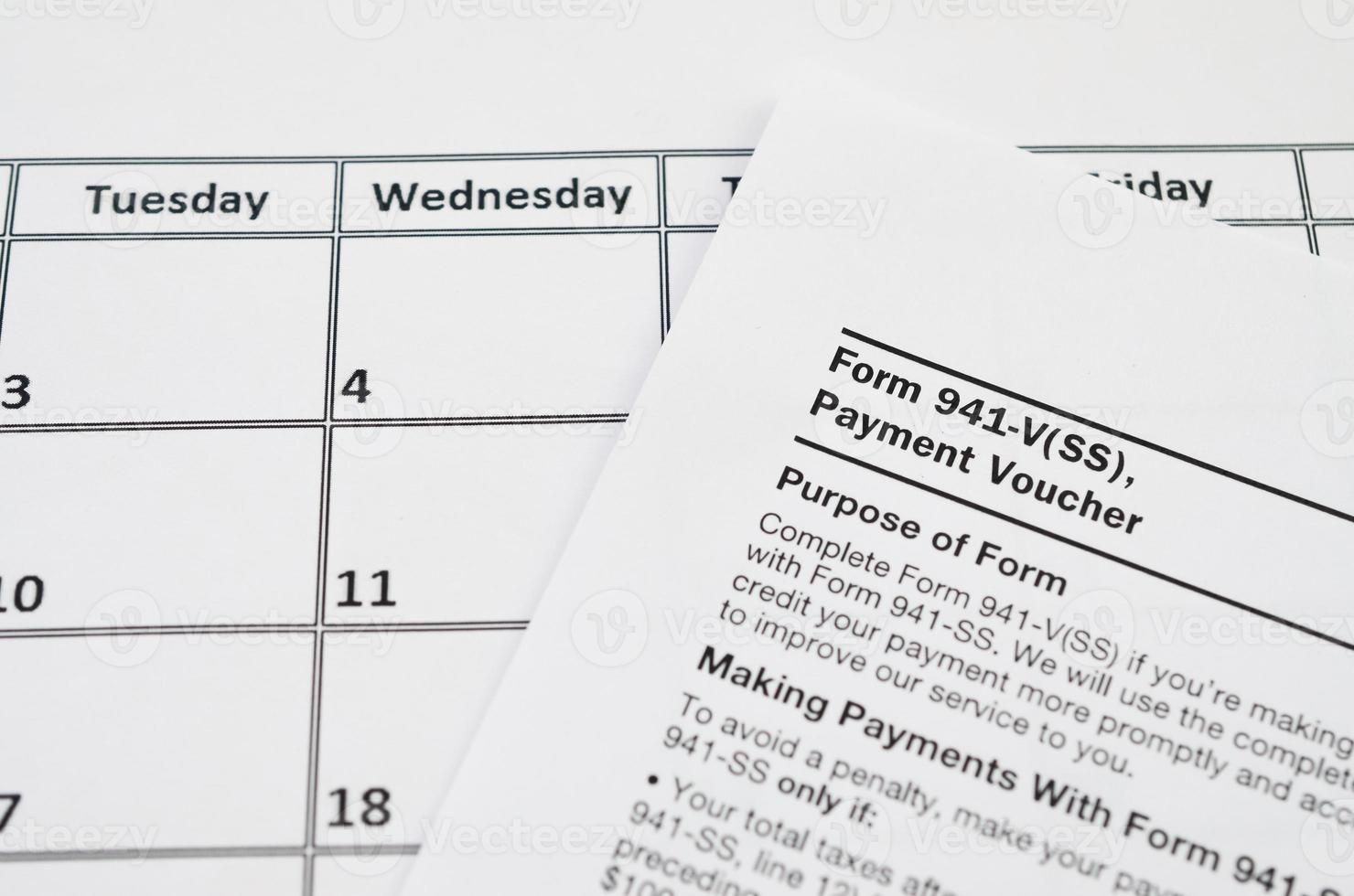 IRS Form 941-V Payment Voucher blank lies on empty calendar page photo