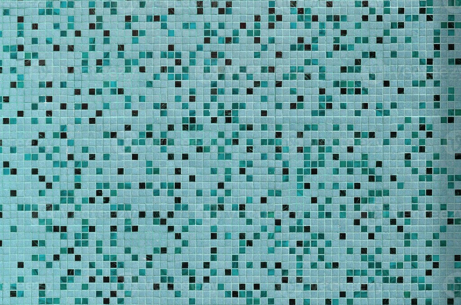 The texture of the wall, decorated with a mosaic of various small square tiles. Abstract pattern of ceramic tiles on the wall photo