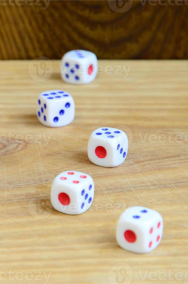 A few dice lies on the surface of natural wood. Items for generating numbers from one to six in the form of points that are painted on the side of cubes. The concept of gambling photo