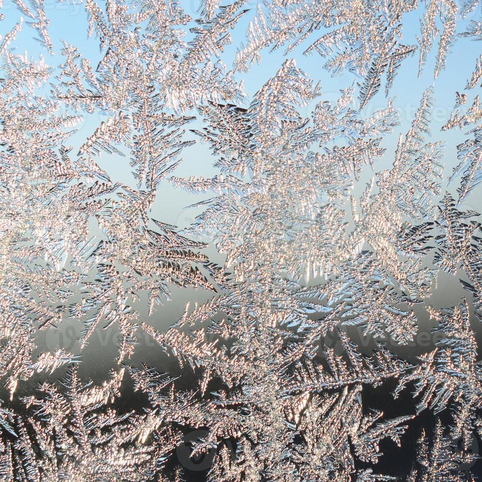 Snowflakes frost rime macro on window glass pane photo