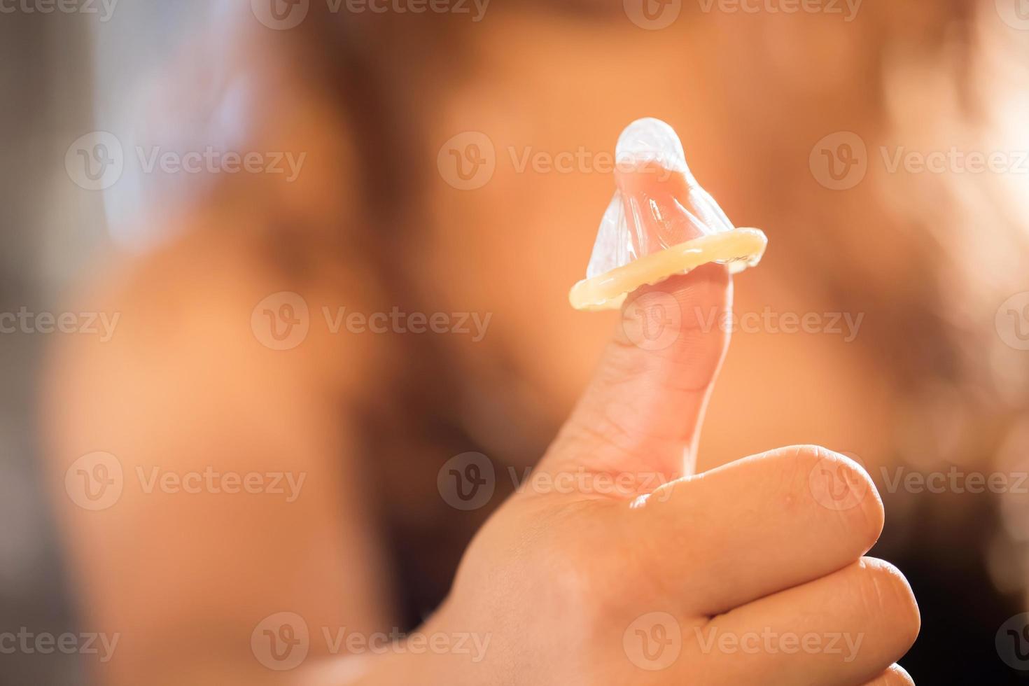 Focus hand,Yong woman use condoms before having sex every time to prevent AIDS. photo